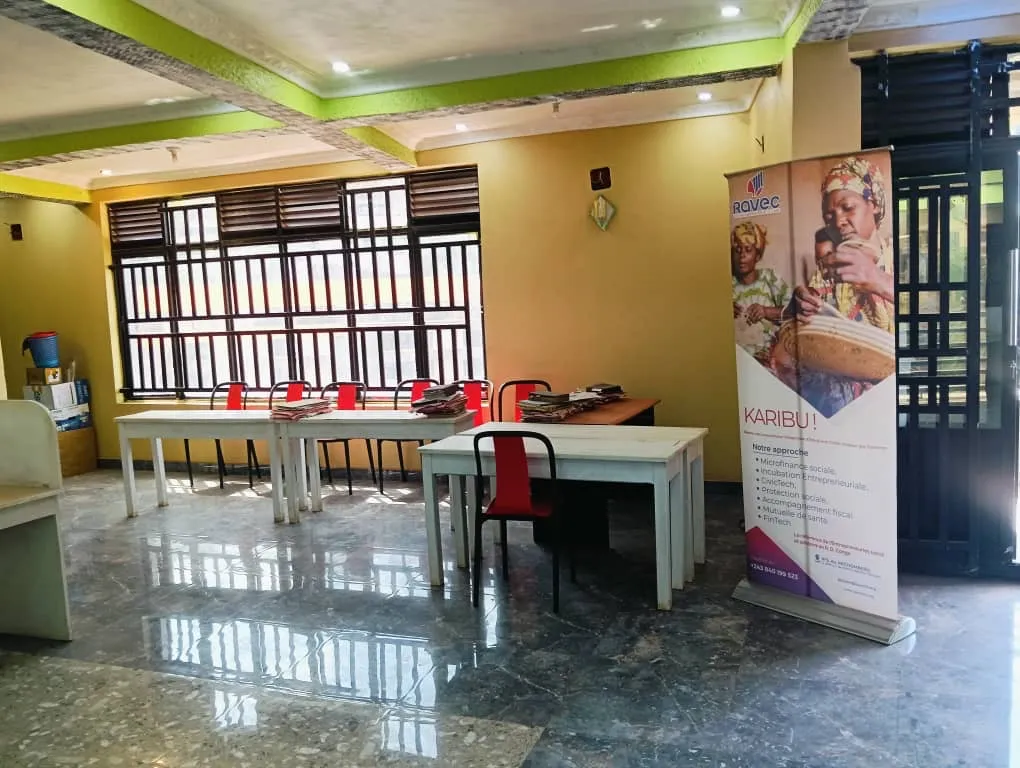 Espace d'accueil lumineux avec tables de travail et kakémono de présentation.