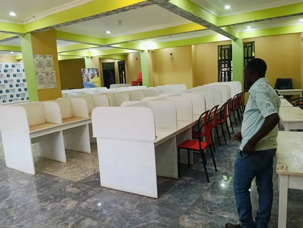 Salle de coworking avec des rangées de postes de travail séparés.