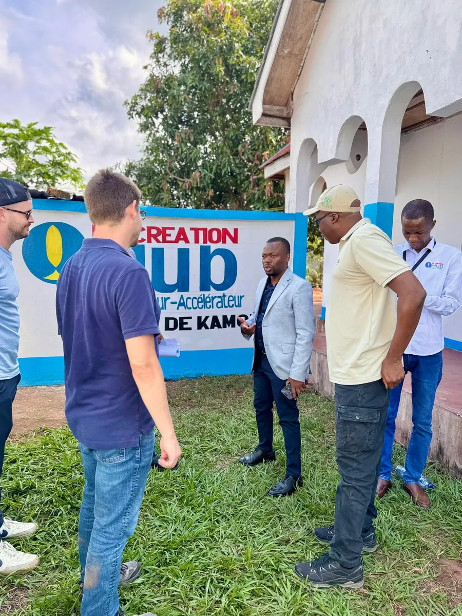 Échange entre l'équipe de LaCreation Hub et des partenaires en visite, devant le mur de l'incubateur-accélérateur.